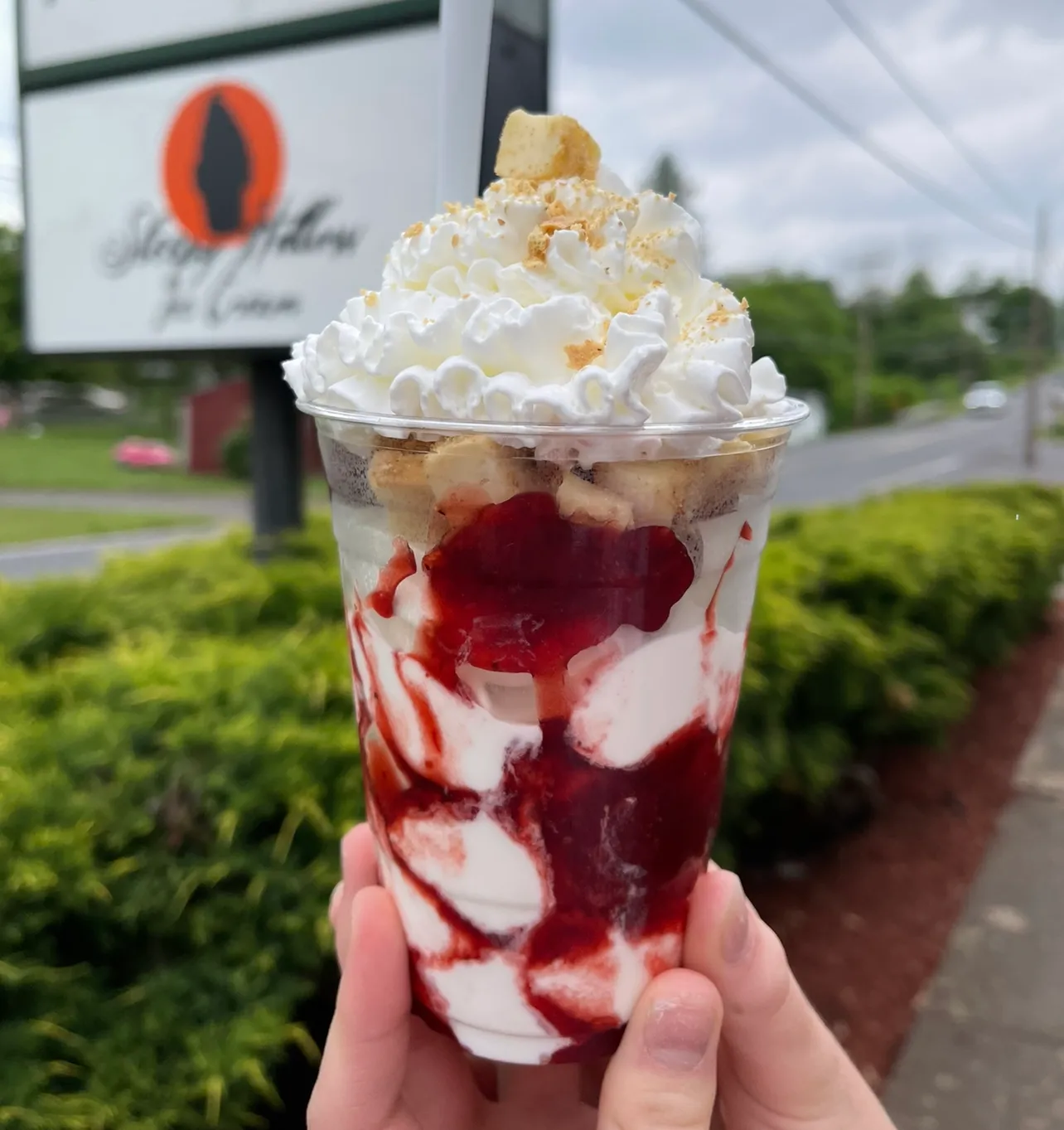 A strawberry sundae in front of the Sleepy Hollow sign