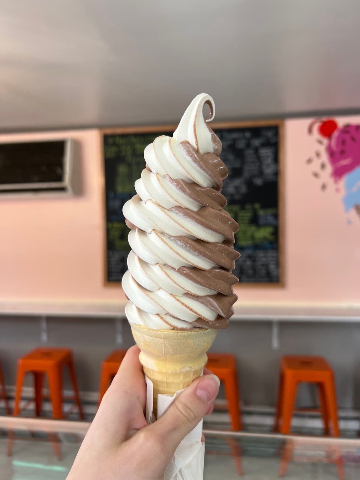 A tall chocolate and vanilla twist cone inside the shop